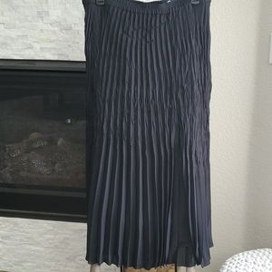 Pleated long skirt with slit in front left side